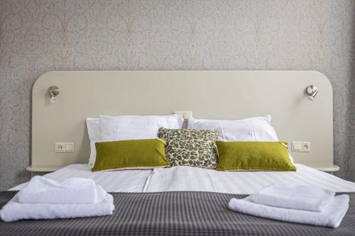 a bed with green and white towels on it at Hotel 1711 in Valkenburg