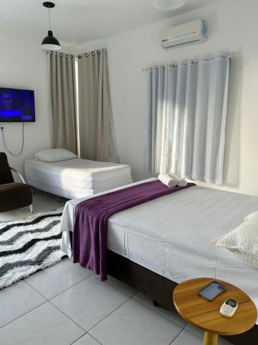 een slaapkamer met 2 bedden en een tafel en een televisie bij SUITE ELEGACY in Serra de São Bento