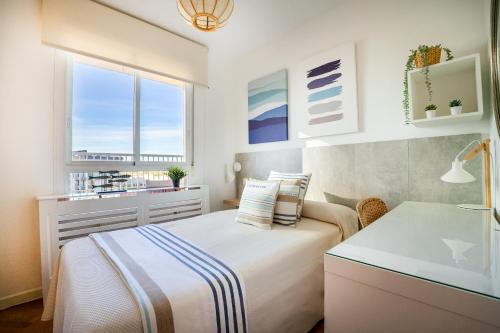 a bedroom with a bed and a sink and a window at Ático con terraza, parking y piscina in Madrid
