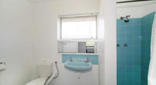 a bathroom with a blue sink and a toilet at Acacia Holiday Or Business Stay - Quiet Location in Perth