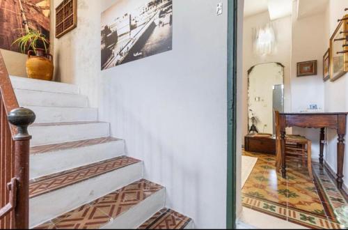 a hallway with stairs and a table and a mirror at Kasa Celeste Aida in Gallipoli