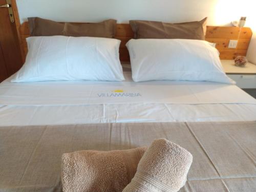 uma cama grande com lençóis brancos e almofadas em Villaggio Residence Villamarina em Marina di Camerota
