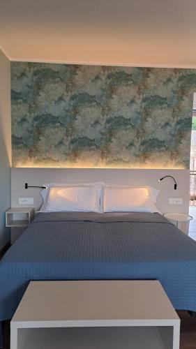una camera da letto con un letto e un dipinto sul muro di Residence San Vito a Brenzone sul Garda
