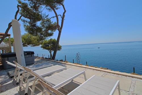 - une table et des chaises installées à côté de l'océan dans l'établissement A couper le souffle ! #Domaine de luxe sur l'eau, à Ensuès-la-Redonne
