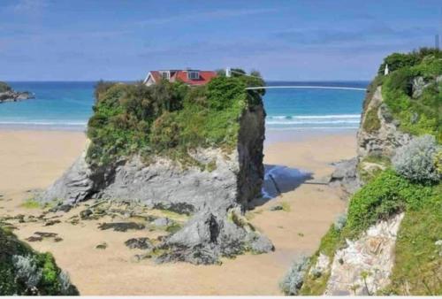 una casa in cima a una scogliera su una spiaggia di Palms 1 - Wood burner, 5 min walk to beach+parking a Newquay