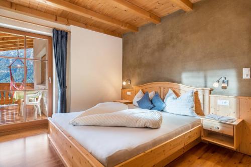 ein Schlafzimmer mit einem großen Bett und einem Fenster in der Unterkunft Ronsolhof Schlern in Seis am Schlern