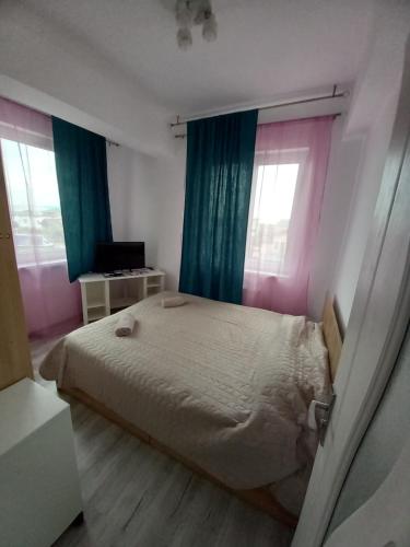 a bedroom with a bed with blue and pink curtains at Twins Residence 2 APART HOTEL Ap 6 2 rooms in Chiajna