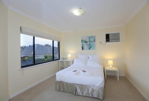 a bedroom with a bed with white sheets and a window at Rancho Relaxo - Great For Longer Stays! Free Wifi in Perth
