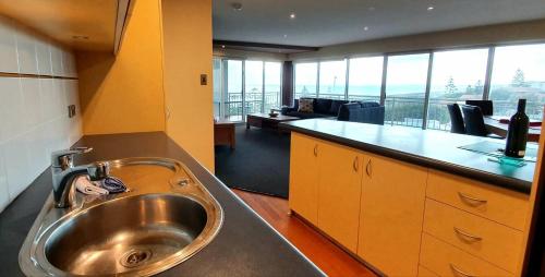uma cozinha com um lavatório e uma sala de estar em Ocean View-breath Taking Views, Amazing Facilities em Perth