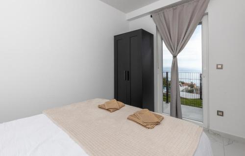 a bedroom with a bed with two brown pillows on it at Nice Home In Bregi With House Sea View in Breza
