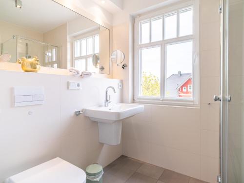 uma casa de banho com um lavatório, um WC e uma janela. em Haus STRANDLUST WF-05 em Wustrow