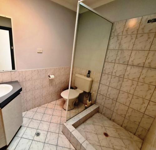 uma casa de banho com um WC e um chuveiro em Ocean's "4" Holiday Or Business Stay Accommodation em Perth