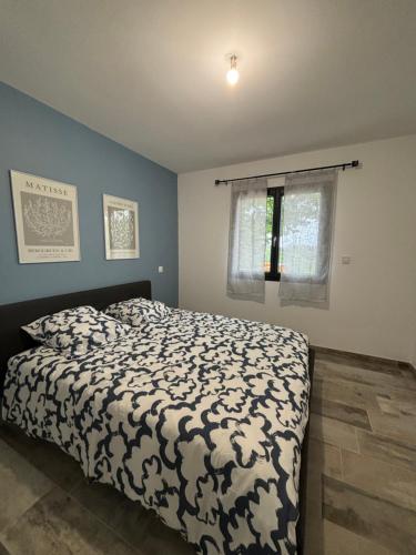 a bedroom with a bed with a black and white comforter at Villa du grangeon in Rosières