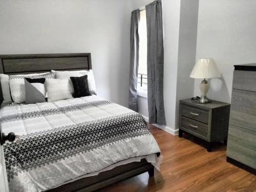 a bedroom with a bed and a dresser and a window at CLINTON HILLS - Newark in Newark