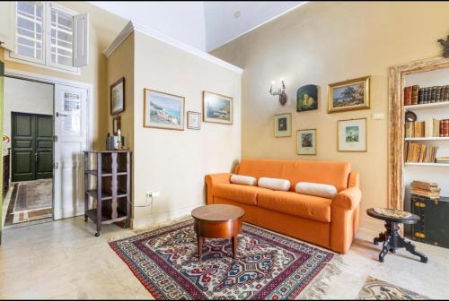 a living room with an orange couch and a rug at Kasa Celeste Aida in Gallipoli