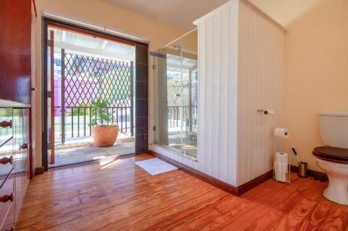 Un baño con inodoro y puerta corrediza de cristal. en Bo-Kaap hidden gem with Hot Tub, en Ciudad del Cabo