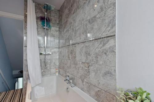 a bathroom with a bath tub with a shower curtain at StayInWoking at 30 Woodlands in Horsell