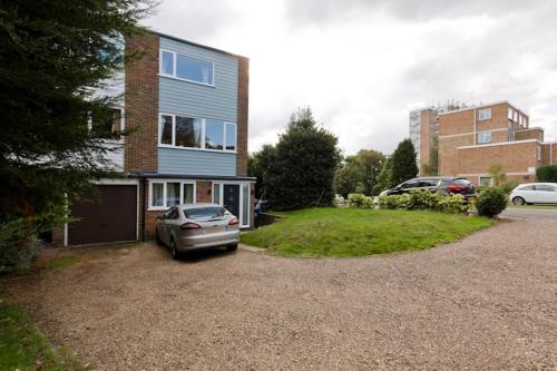 a car parked in the driveway of a house at StayInWoking at 30 Woodlands in Horsell
