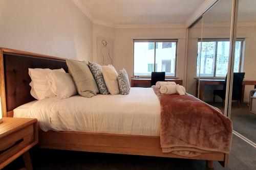 una camera da letto con un letto con un orsacchiotto sopra di Sandcastles Beachfront Luxury Retreat Apartment a Perth