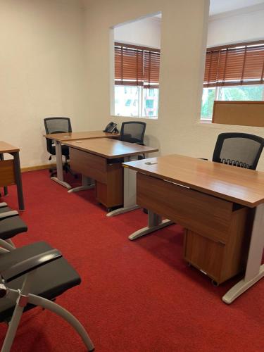 Park Place Business Center في نيروبي: مكتب فيه طاولات وكراسي في الغرفة
