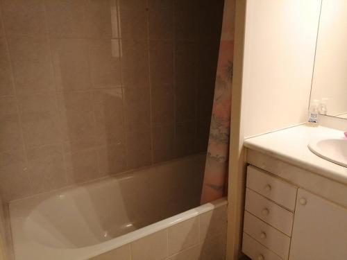 une salle de bain avec une baignoire et un lavabo dans l'établissement La baie et mer de Sion, à Saint-Hilaire-de-Riez