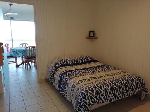 une chambre avec un lit dans une pièce avec une table dans l'établissement La baie et mer de Sion, à Saint-Hilaire-de-Riez