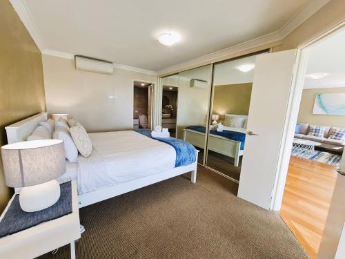 1 dormitorio con 1 cama blanca grande y 1 habitación con en Clifton On Scarborough - Absolute Beachfront, en Perth