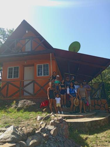 a group of people standing in front of a house at Cabaña sinfonía natural in El Quije