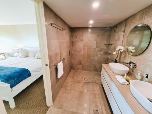 y baño con cama, bañera y lavamanos. en Clifton On Scarborough - Absolute Beachfront, en Perth