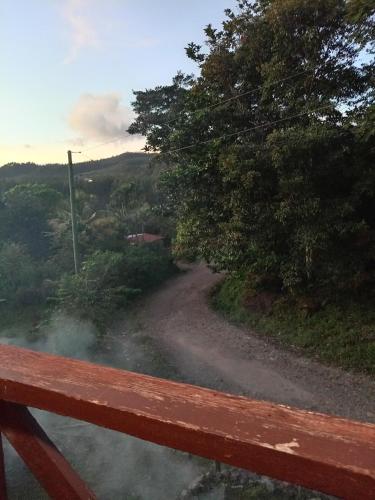 a view of a dirt road from a wooden bench at Cabaña sinfonía natural in El Quije