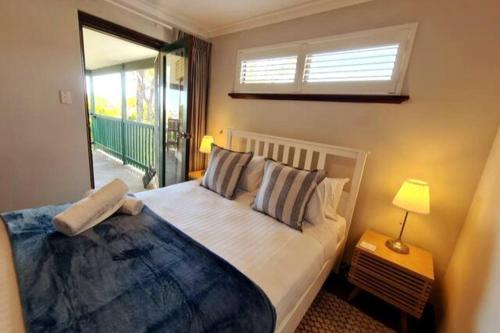 Schlafzimmer mit einem großen Bett und einem Fenster in der Unterkunft Summer Breeze - Holiday Or Business Apartment in Perth