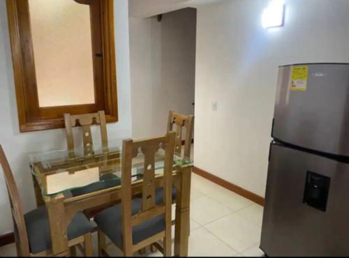 a kitchen with a table and a stainless steel refrigerator at Apartamento 502 in Itagüí