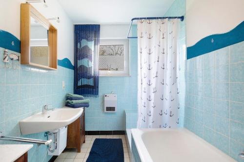 y baño azul con lavabo y bañera. en Bikerhäusle, en Gerstetten