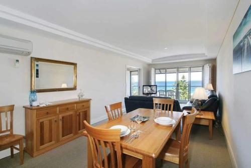 a dining room with a wooden table and chairs at The Sea Breeze Penthouse Apartment in Perth