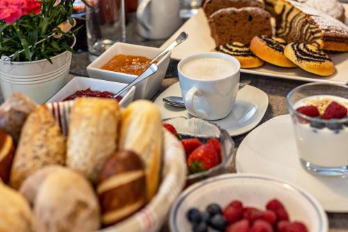 a table with plates of pastries and cups of coffee at Krämerhof Apt Aferer Geisler in Rodengo