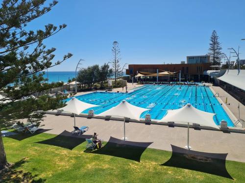 a large swimming pool with blue water at Sea Breeze Apartment - Direct Ocean Views - Top Floor in Perth