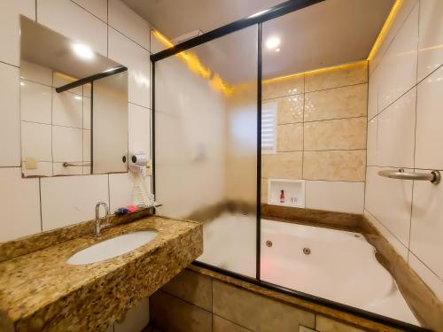 a bathroom with a sink and a shower at Adrenalina Motel Itaquera - Arena Corinthians in São Paulo