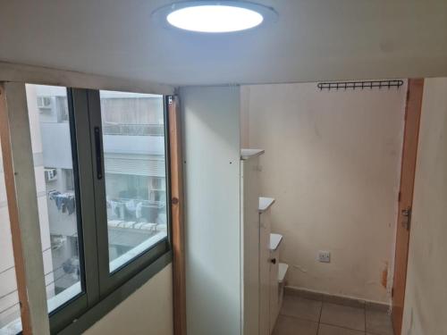 La salle de bains est pourvue d'une porte en verre et d'une fenêtre. dans l'établissement Al karama spacious hostel, à Dubaï