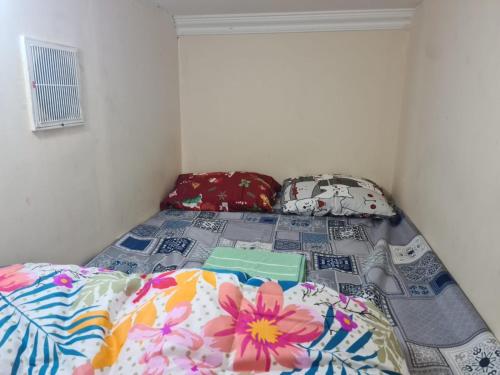 a bedroom with a bed with colorful sheets and pillows at Al karama spacious hostel in Dubai