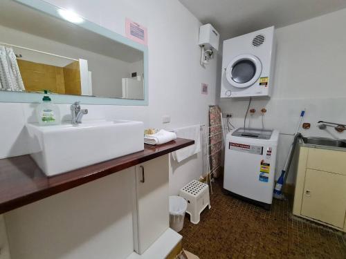 a small kitchen with a sink and a microwave at West Beach Lagoon 202 - Quiet & Ground Floor! in Perth