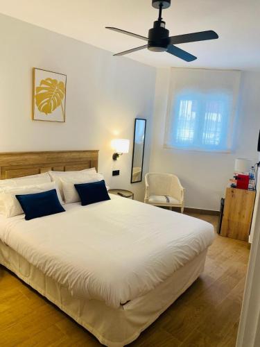 a bedroom with a large bed with a ceiling fan at El Parador del César Boutique, Aparcamiento Gratis in Mérida