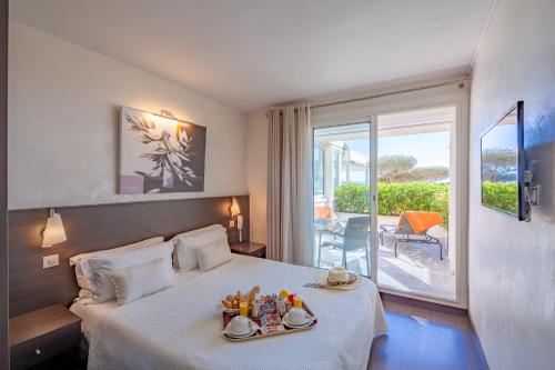 une chambre d'hôtel avec un lit et de la nourriture dans l'établissement Hôtel La Plage, à Sainte-Maxime
