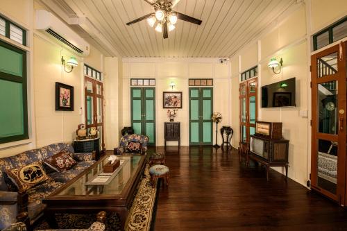 a living room with a couch and a table at Wallaya Heritage Stay in Bangkok