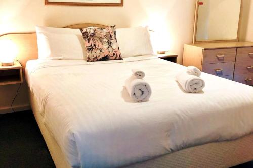 - une chambre avec un lit blanc et des serviettes dans l'établissement West Beach Lagoon 216 - Quiet & Relaxing, à Perth