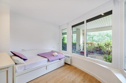 Schlafzimmer mit einem Bett und großen Fenstern in der Unterkunft Zona Hospitales y Clinica Universitaria - TuApartamento in Pamplona
