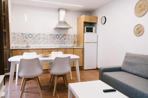 Una cocina y una sala de estar con una mesa y un sofá. en Casa Ochavada, en Archidona