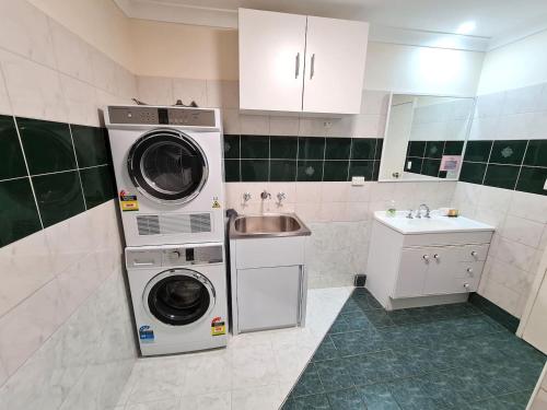 a kitchen with a washer and dryer and a sink at Seashore Memories - Sleeps 3 in Perth