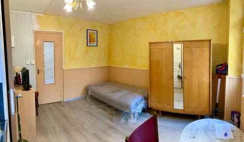 une chambre avec un lit dans le coin d'une pièce dans l'établissement Studio 18m2 centre bourg, à Lazenay