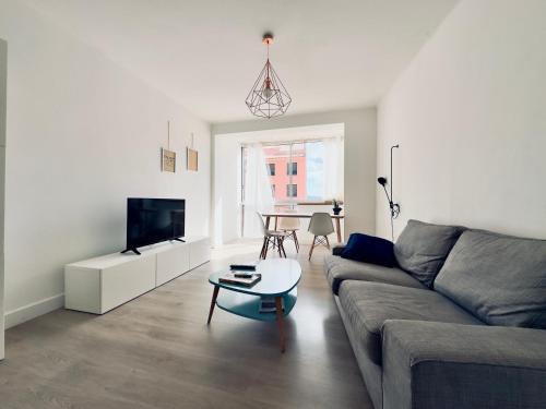 ein Wohnzimmer mit Sofa und Tisch in der Unterkunft L'Ajax Appartement T3 centre et Bord de mer in Ajaccio