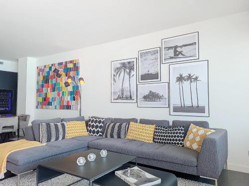 - un salon avec un canapé bleu et des photos sur le mur dans l'établissement Nestor&Jeeves - LE ROYAL LUXEMBOURG - Sea view - Terrace, à Nice